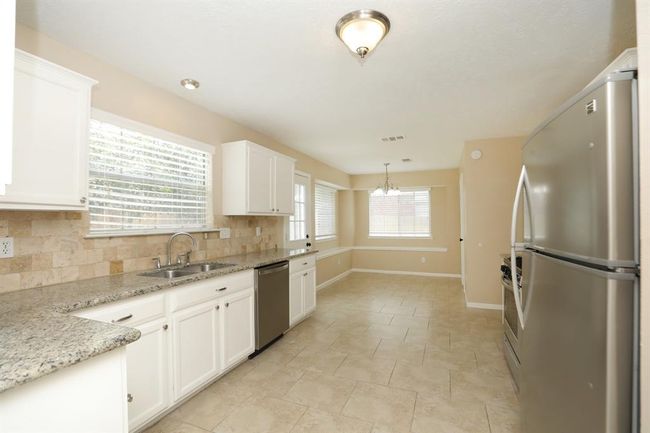 Updated kitchen with stainless appliances, gas range, and granite counters. | Image 11