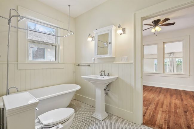 Full bath with a freestanding tub, wainscoting, and a ceiling fan | Image 16