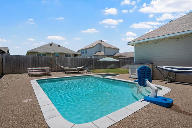 View of swimming pool with a fenced backyard | Image 31