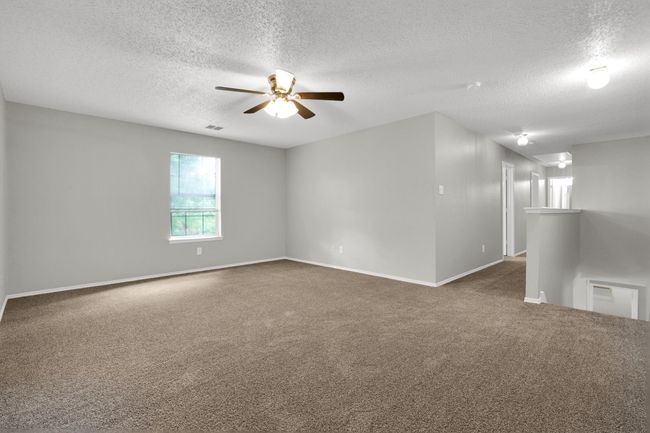 Unfurnished room with carpet flooring, a textured ceiling, ceiling fan, and baseboards | Image 22
