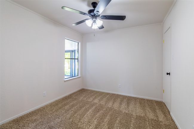 Carpeted spare room with baseboards, ceiling fan, and crown molding | Image 14