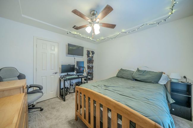 Bedroom featuring light colored carpet and a ceiling fan | Image 28