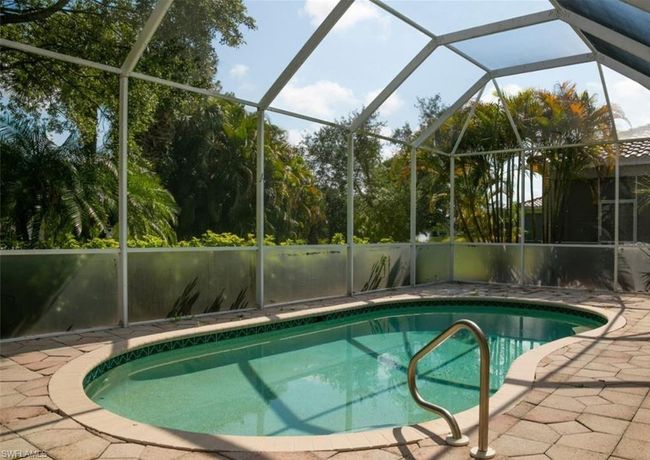 View of pool with glass enclosure and a patio area | Image 14