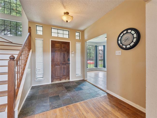 Entryway with stairs, a textured ceiling, and stone finish floors | Image 6