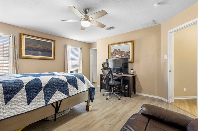 Bedroom with light wood finished floors, a textured ceiling, visible vents, and a ceiling fan | Image 24