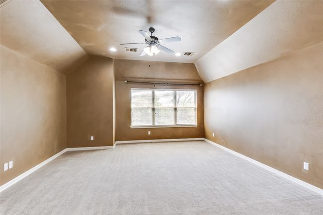 Bonus room featuring a ceiling fan, lofted ceiling, and visible vents | Image 26
