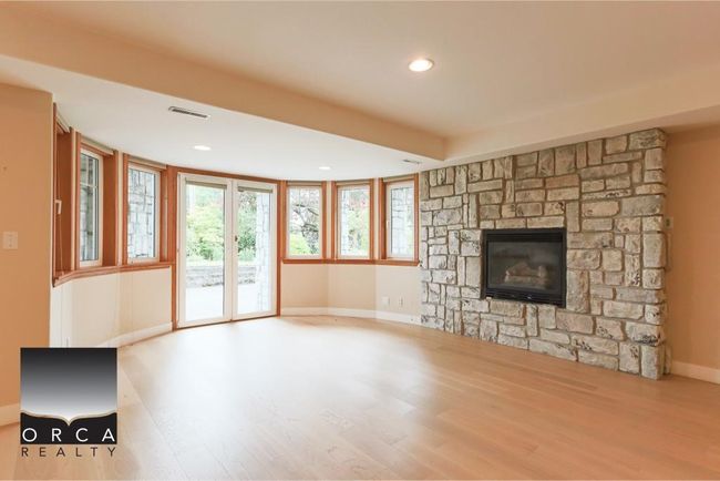 Unfurnished living room with wood finished floors, a fireplace, and recessed lighting | Image 30