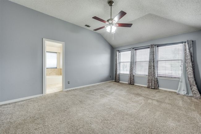 Unfurnished room with lofted ceiling, carpet flooring, healthy amount of natural light, a textured ceiling, and ceiling fan | Image 12