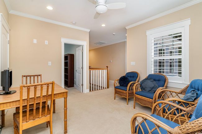 Sitting room featuring a ceiling fan, light colored carpet, and crown molding | Image 30