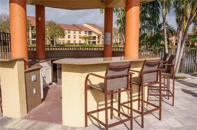 View of patio with outdoor dry bar, area for grilling, and fence | Image 34