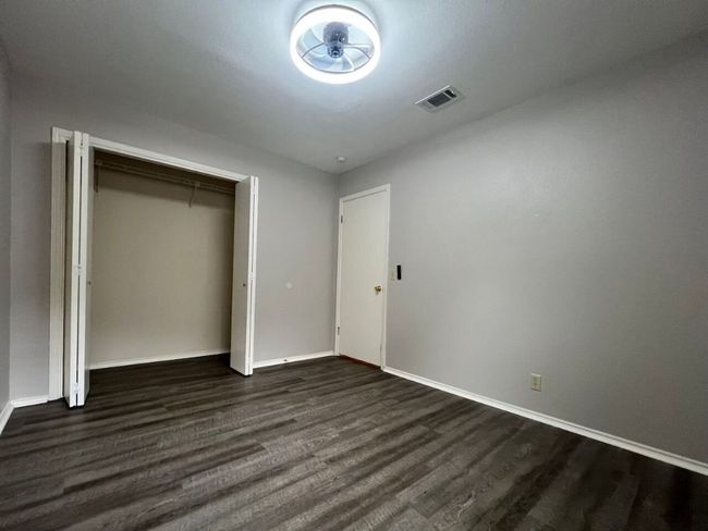 Unfurnished bedroom with dark wood-style flooring and a closet | Image 29