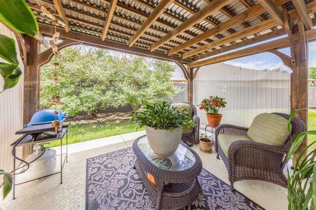 Adjacent to the sun room, a pergola offers additional seating space, creating a charming outdoor retreat. The structure enhances the area with its inviting design, providing a perfect spot for relaxation and enjoying the surrounding views. | Image 29