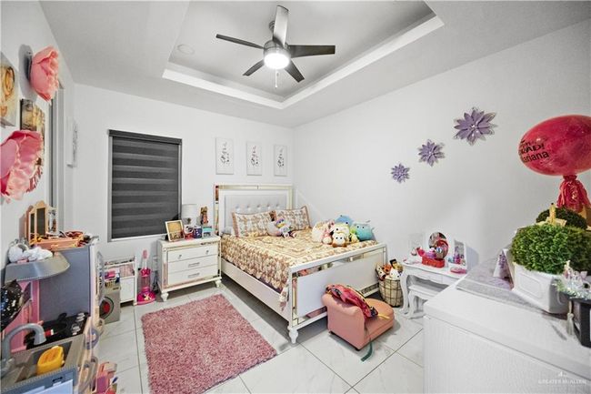 Bedroom with a raised ceiling and ceiling fan | Image 15
