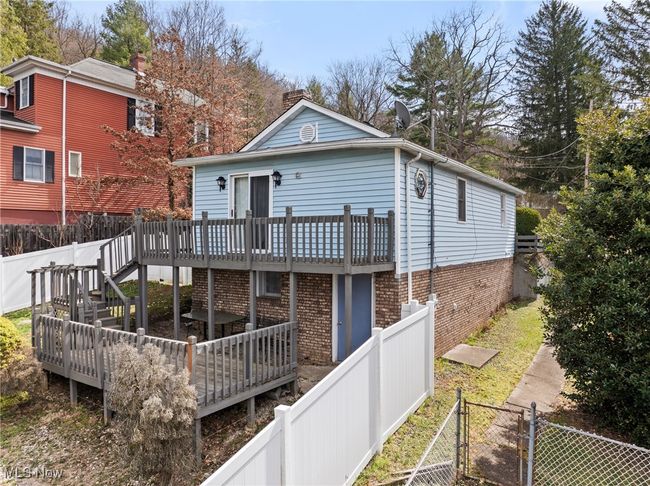 Back of house with a fenced backyard, a chimney, a gate, and a wooden deck | Image 21