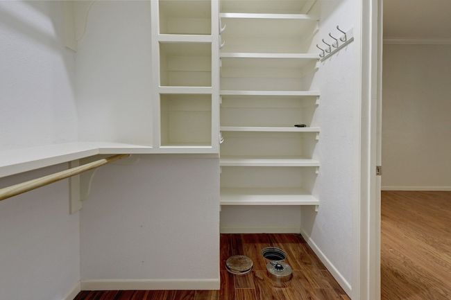 Large walk-in closet in primary bedroom with built-in storage. | Image 15