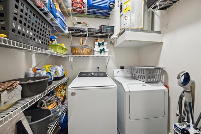 The laundry room, located just off the foyer, offers ample shelving and storage. Adjacent to it is a tucked-away closet, perfect for additional storage needs. | Image 15