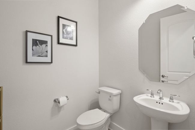 Bathroom with toilet, baseboards, and a sink | Image 21