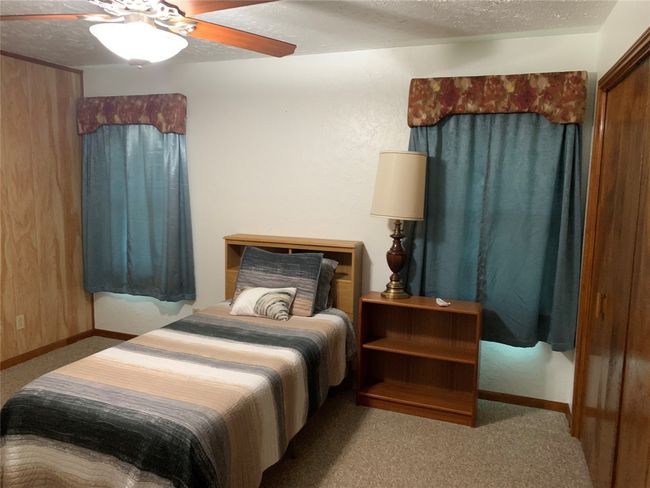 Carpeted bedroom with a textured ceiling and a ceiling fan | Image 5