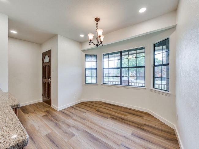 Unfurnished dining area featuring a chandelier, light wood-style flooring, and recessed lighting | Image 6