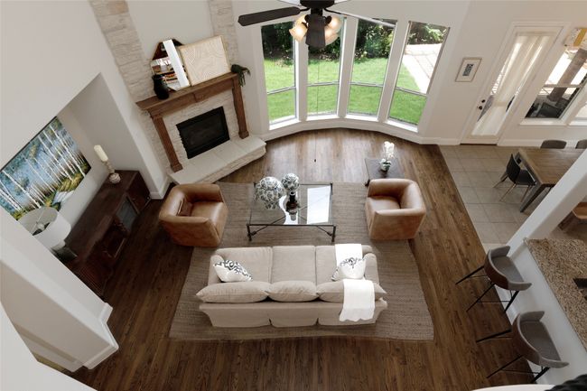 Living room with wood finished floors, a ceiling fan, and a fireplace | Image 26