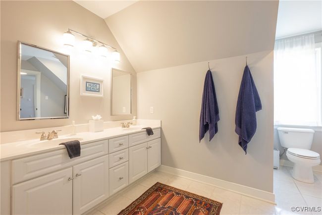Full bath featuring toilet, double vanity, a sink, and lofted ceiling | Image 26