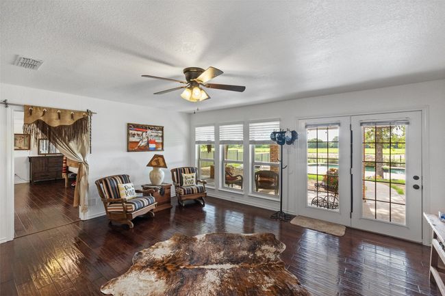 Living area featuring a textured ceiling, ceiling fan, visible vents, and plenty of natural light | Image 12