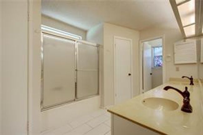 Full bath with tile patterned floors, vanity, and enclosed tub / shower combo | Image 18