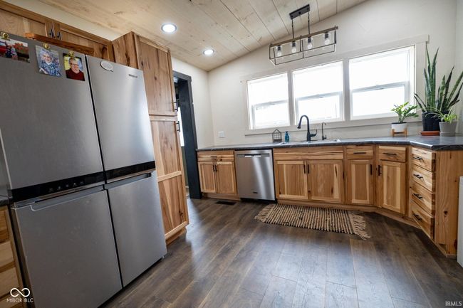 kitchen featuring stainless steel appliances, dark wood-style floors, wood ceiling, and a sink | Image 5