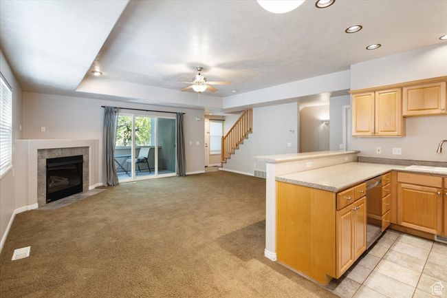 Kitchen with a peninsula, a ceiling fan, light countertops, open floor plan, and recessed lighting | Image 8