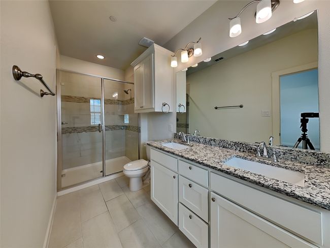 Full bath featuring tile patterned flooring, a stall shower, toilet, double vanity, and recessed lighting | Image 7