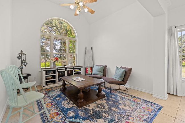 Sitting room with a ceiling fan, tile patterned floors, and high vaulted ceiling | Image 8