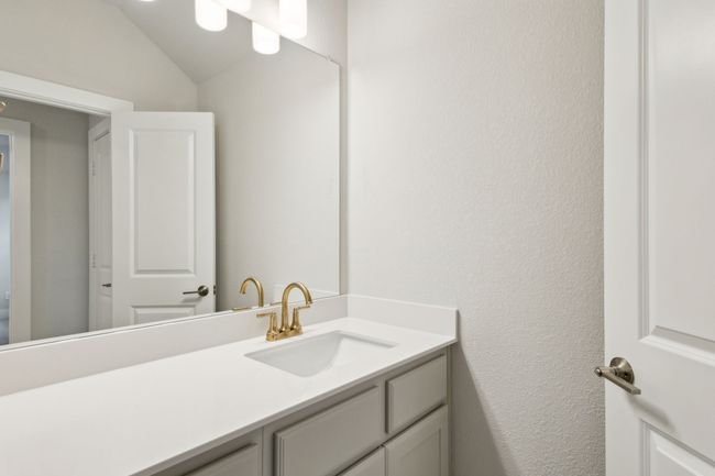 Bathroom with vanity, lofted ceiling, and a textured wall | Image 24