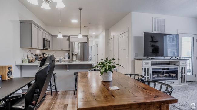 Dining space with light wood finished floors, visible vents, and a fireplace | Image 8