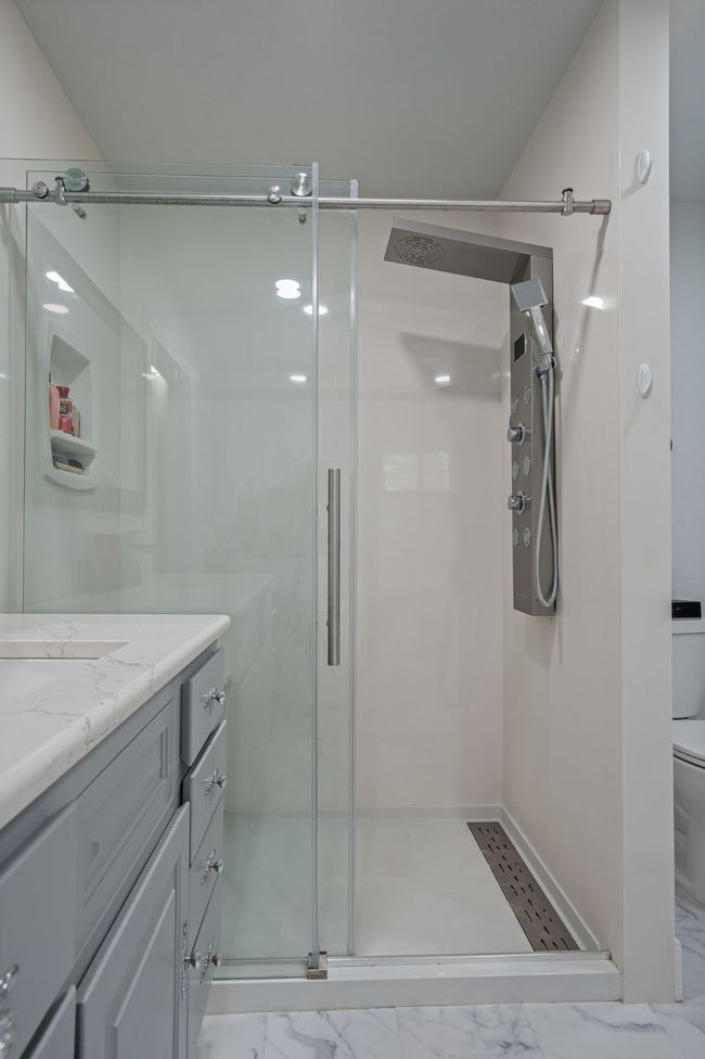Bathroom with vanity, a stall shower, and marble look tiles | Image 20
