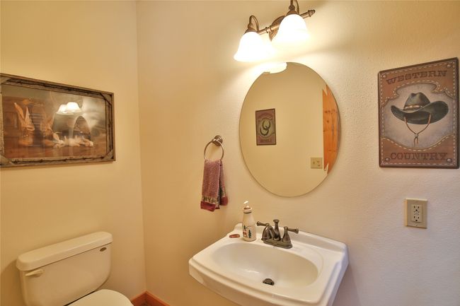 Half bathroom featuring a sink and toilet off of the mudroom. | Image 20