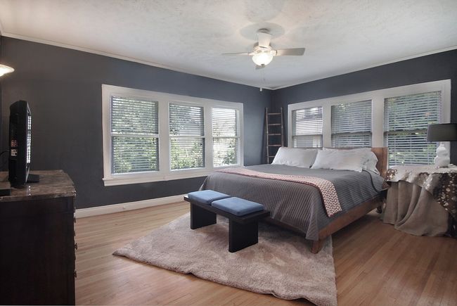 Bedroom featuring a ceiling fan, a textured ceiling, light wood-type flooring, baseboards, and ornamental molding | Image 11