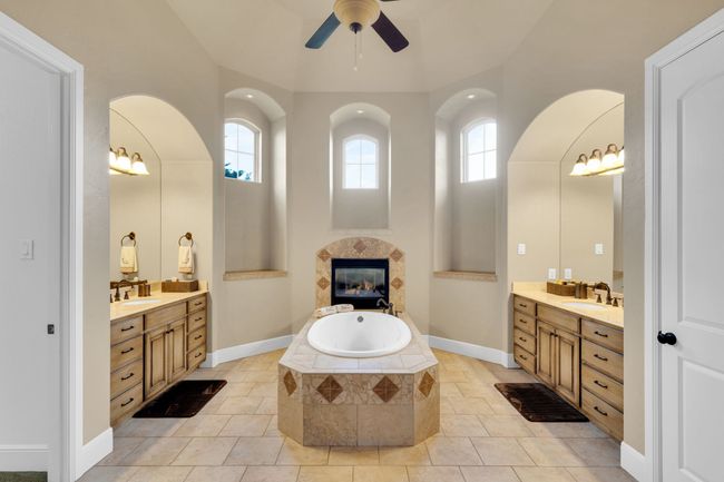 Bathroom with two vanities, plenty of natural light, a fireplace and a ceiling fan | Image 22