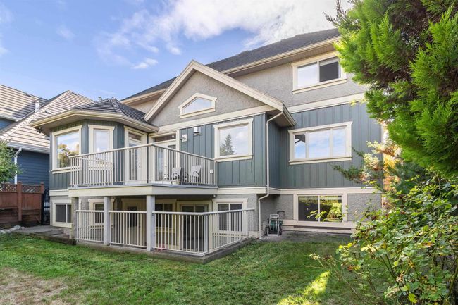 Back of property with board and batten siding, a yard, and a balcony | Image 11