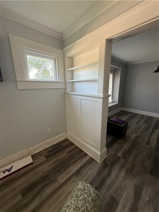Empty room with ornamental molding, dark wood-style floors, and baseboards | Image 7
