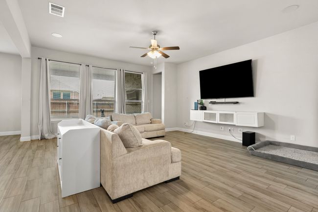 Living area featuring a ceiling fan, light wood-style flooring, and recessed lighting | Image 6