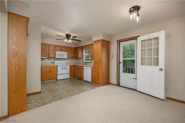 Kitchen featuring white appliances, healthy amount of natural light, light countertops, and a ceiling fan | Image 9