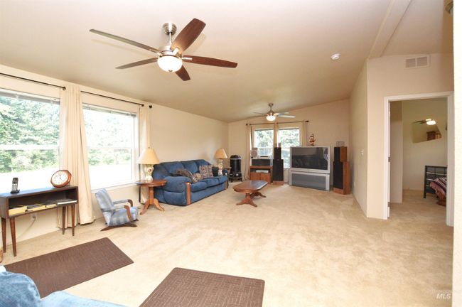 Living room with a ceiling fan, light carpet, and vaulted ceiling | Image 5