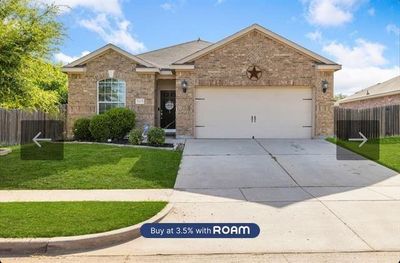 View of front of property featuring a front yard and a garage | Image 1