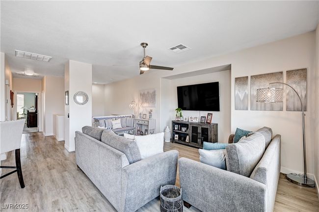 Living area with light wood finished floors and a ceiling fan | Image 10