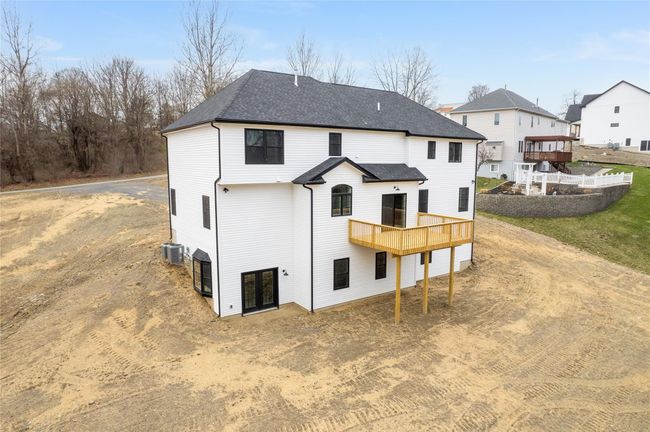 Rear view of house with central AC unit, a deck, and a shingled roof | Image 40