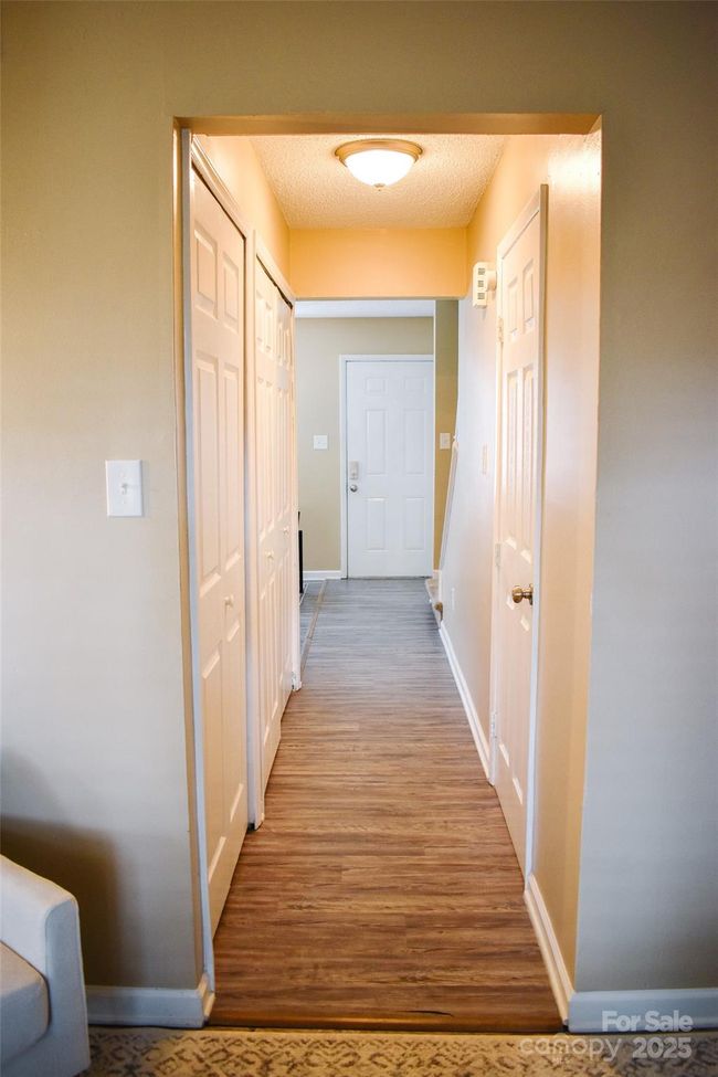 Hallway from the front to the back. Door on left leads to half bath and doorway to the right leads to the. laundry room. | Image 30