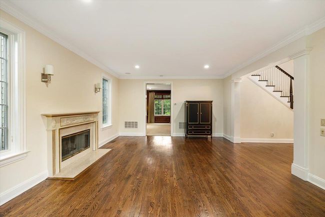 Unfurnished living room featuring wood finished floors, a high end fireplace, recessed lighting, baseboards, and ornamental molding | Image 5
