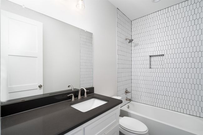 Full bathroom with vanity, tiled shower / bath combo, and toilet | Image 8