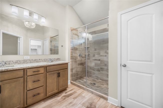 Full bath featuring a stall shower, double vanity, wood finished floors, and a closet | Image 26