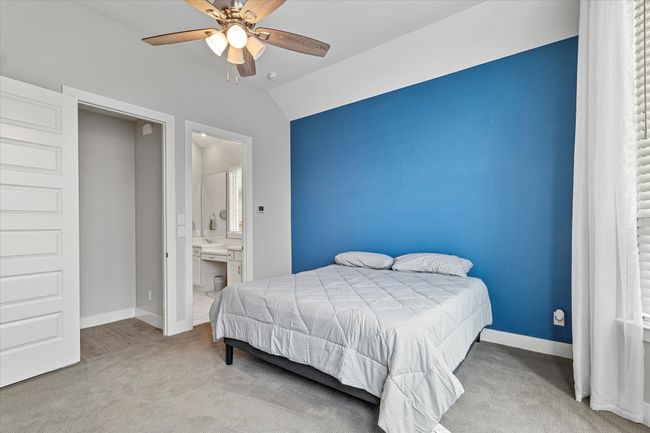 Bedroom with lofted ceiling, baseboards, a ceiling fan, carpet, and ensuite bath | Image 11